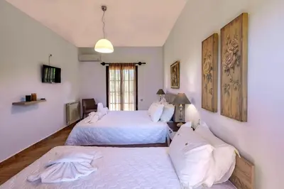 a bedroom with two beds and a window at Exclusive Crete Villa Villa Alexia 4 Bedrooms Large Lawned Gardens in Maleme