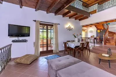 a living room with a table and a tv at Exclusive Crete Villa Villa Alexia 4 Bedrooms Large Lawned Gardens in Maleme
