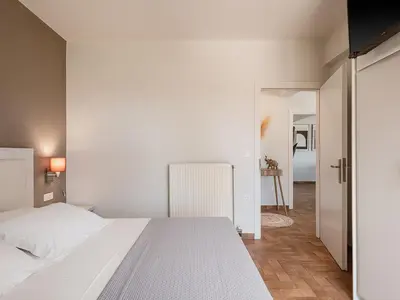 a bedroom with a white bed and a hallway at Villa Anemeli - Luxury pool villa with gorgeous seaview in Kissamos