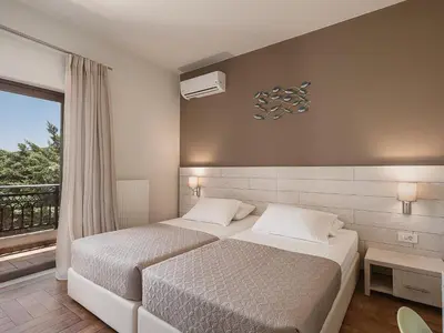 a bedroom with two beds and a window at Villa Anemeli - Luxury pool villa with gorgeous seaview in Kissamos