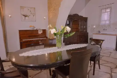 a dining room with a table with a vase of flowers at Villa Kamares Private pool in Kondomari