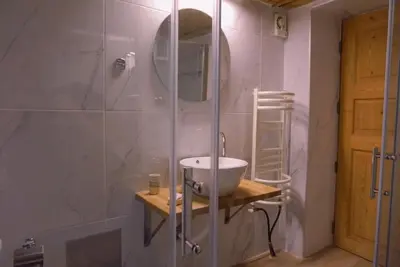 a bathroom with a shower with a sink and a mirror at Villa Kamares Private pool in Kondomari