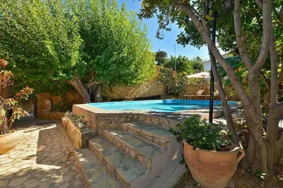 a swimming pool with a stone wall and stairs around it at Villa Kamares Private pool in Kondomari