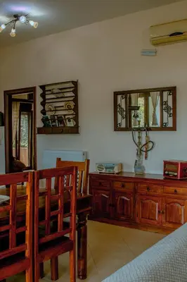 a dining room with a table and a wooden dresser at Villa Kalamitsi Luxury Villa in Apokorona Chania in Kariá