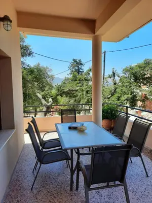 a blue table and chairs on a balcony with a view at Villa Maragoudi in Arménoi