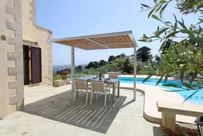 a patio with a table and chairs and a pool at Casa Rustica in Xirokámbion