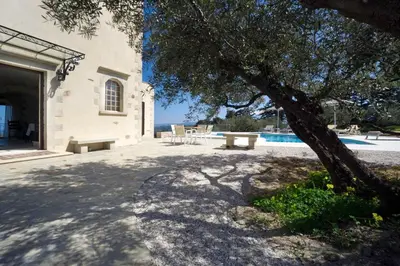 a patio with a table and a tree next to a pool at Casa Rustica in Xirokámbion