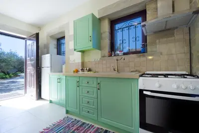 a kitchen with green cabinets and a sink and a stove at Casa Rustica in Xirokámbion
