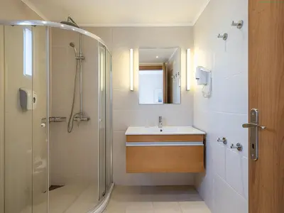 a bathroom with a sink and a glass shower at Caldera Beach in Plataniás