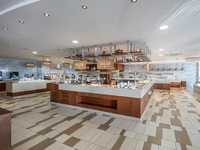 a large kitchen with a counter in a restaurant at Caldera Beach in Plataniás