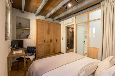 a bedroom with a bed and a desk and a television at The Peach House in Chania Town