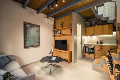 a living room with a couch and a tv and a kitchen at The Peach House in Chania Town