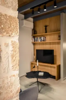 a living room with a fireplace and a television at The Peach House in Chania Town