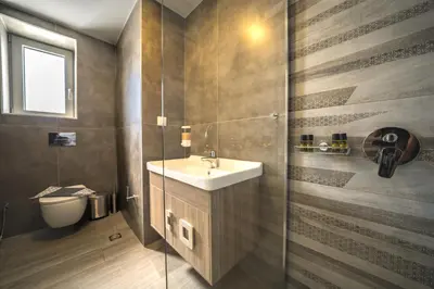 a bathroom with a sink and a glass shower at Nafsika Xenia Villa in Plátanos
