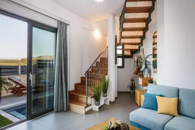 a living room with a blue couch and a staircase at Villa Chryssi in Kissamos
