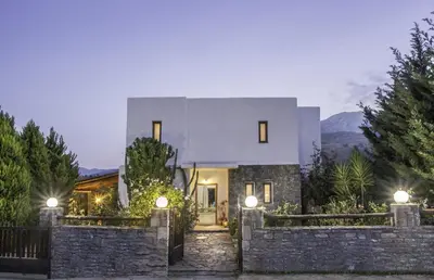a house with a stone fence in front of it at Villa Kalithea in Pemónia