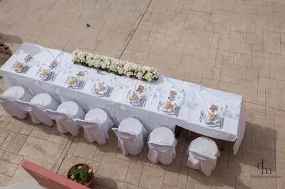 an overhead view of a white table with flowers on it at Haridimos Apartments in Tavronitis