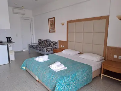 a bedroom with a bed with two towels on it at Haridimos Apartments in Tavronitis