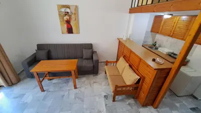 a living room with a table and a couch at Artemis Studios in Agia Roumeli