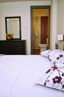 a bedroom with a bed and a bathroom with a mirror at Anemon Villas in Kissamos