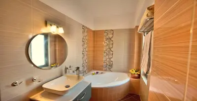 a bathroom with a sink and a tub and a mirror at Anemon Villas in Kissamos