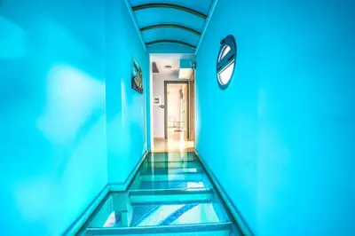 a hallway with blue walls and a clock on the wall at Anemon Villas in Kissamos