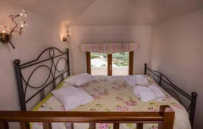 a bedroom with a bed with pillows and a window at Athina Luxury Villas in Xamoudhokhórion