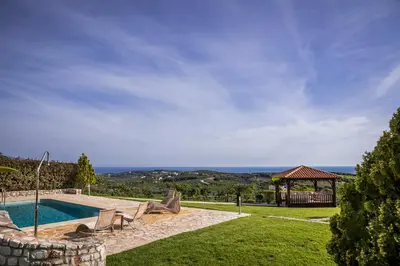a backyard with a swimming pool and a gazebo at Athina Luxury Villas in Xamoudhokhórion
