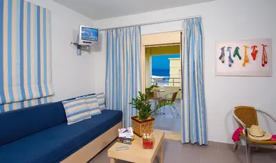 a living room with a blue couch and a table at Lissos Beach in Plataniás