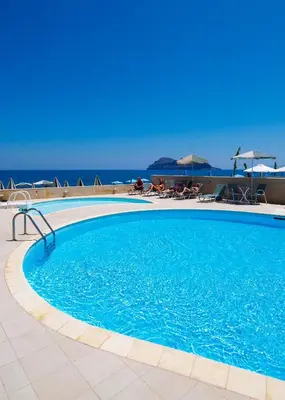 a swimming pool with the ocean in the background at Lissos Beach in Plataniás