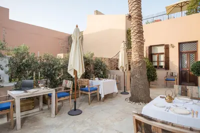 a patio with tables and umbrellas in a resort at La Maison Ottomane in Chania Town