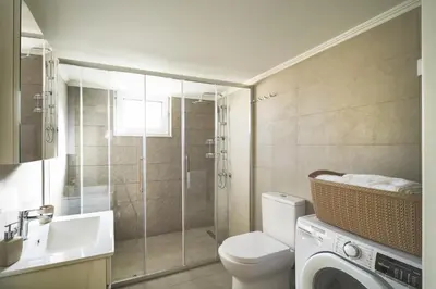 a bathroom with a toilet and a sink and a washing machine at Villa Calliope in Chania Town
