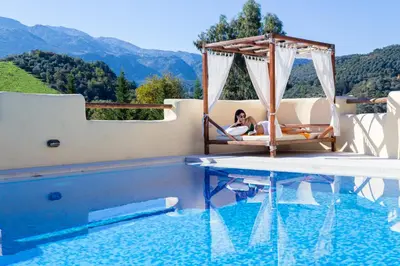 a woman laying on a swing next to a swimming pool at Verekinthos Villas - Pool, Hot Tub, BBQ, Kids Playground, Stunning Mountain Views in Gerolakkos