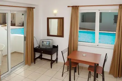 a room with a desk and a table with a television at Thodorou Village in Agia Marina Nea Kydonias