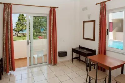 a dining room with a table and a desk and a window at Thodorou Village in Agia Marina Nea Kydonias