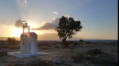 a small chapel in the desert with the sunset in the background at Zefyros Apartments and House in Kissamos