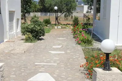 a walkway in a garden with flowers at Zefyros Apartments and House in Kissamos