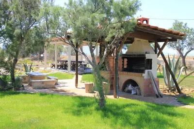 a outdoor pizza oven in a yard with green grass at Zefyros Apartments and House in Kissamos