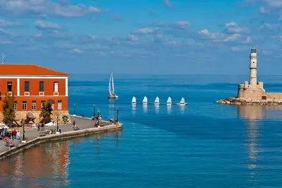 a lighthouse in the ocean with sailboats in the water at Comfy Apartment in Chania Town