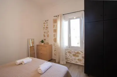 a bedroom with a bed and a window at Comfy Apartment in Chania Town