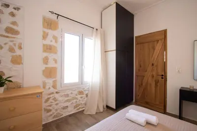 a bedroom with a bed and a window and a door at Comfy Apartment in Chania Town