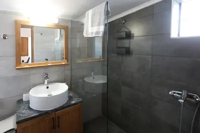 a bathroom with a sink and a shower with a mirror at Comfy Apartment in Chania Town