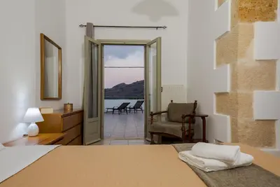 a bedroom with a bed and a view of the ocean at Basilikos traditional house, 10' from Falasarna in Kissamos