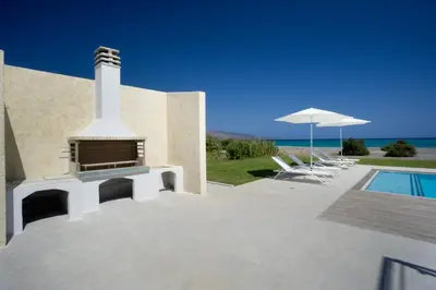 a house with a fireplace and a swimming pool at Beach Villas in Chania Town