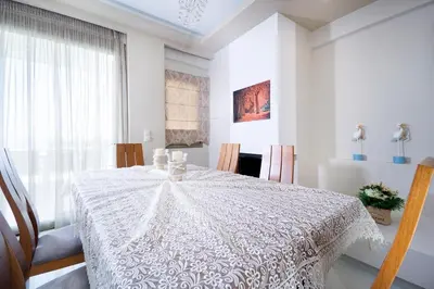 a white dining room table with a white table cloth at Beach Villas in Chania Town