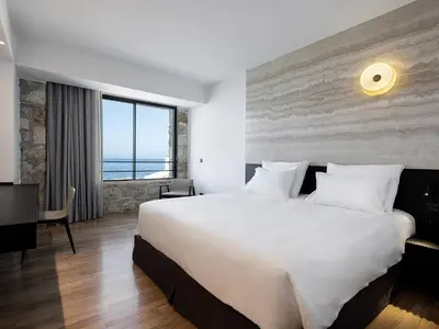 a hotel room with a large bed and a view of the ocean at The Tanneries Hotel & Spa - a Member of Design Hotels in Chania Town