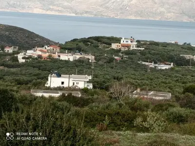a group of houses on a hill next to the water at TRADITIONAL HOUSE MARIA in Azoyirás