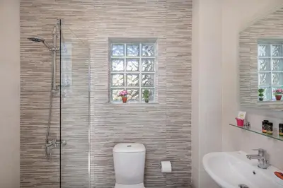 a bathroom with a toilet and a sink and a window at M City Apartments 100m from the beach in Chania Town