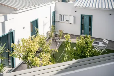 an external view of a white house with plants at M City Apartments 100m from the beach in Chania Town