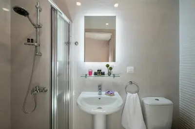 a bathroom with a sink and a toilet and a mirror at M City Apartments 100m from the beach in Chania Town